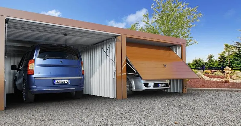 Zwei Autos, die in einer modernen Doppelgarage mit Schwingtoren geparkt sind. Auf der linken Seite steht ein blauer Van, auf der rechten Seite ein silberner Sportwagen, teilweise hinter dem geöffneten Garagentor verborgen.